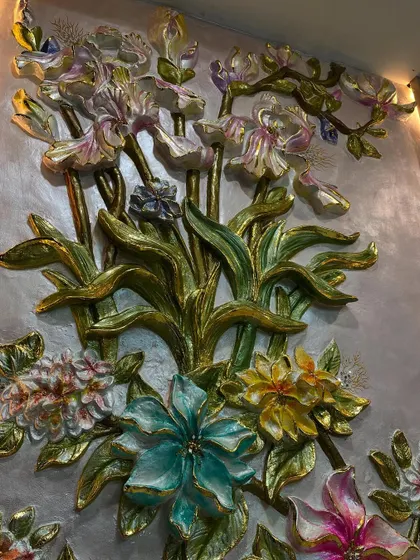 A detailed view of the upper section of the floral arrangement, showcasing the delicate iris flowers and lush green leaves.