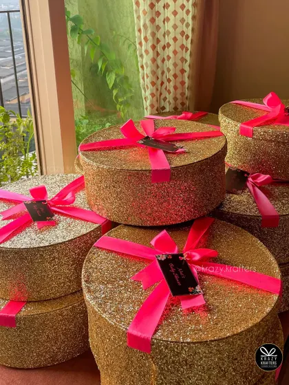 Glamorous baby shower return favors! These glittery gold boxes with neon pink ribbons were a huge hit for a mom-to-be's celebration.