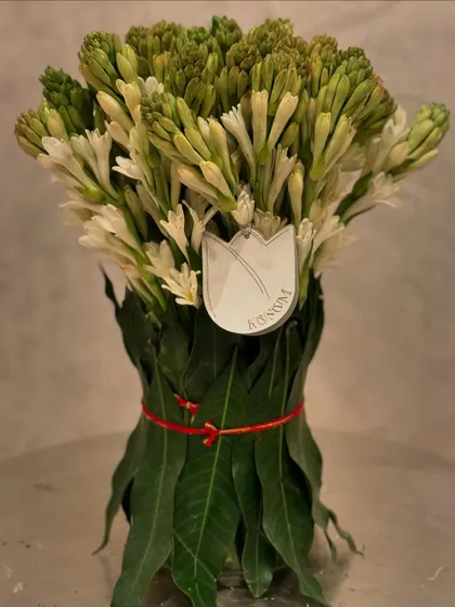 Invite luxury into your home this Diwali. A simple yet elegant bouquet of tuberose, with its stems wrapped in fresh mango leaves, brings a beautiful fragrance and a touch of tradition to your celebration.