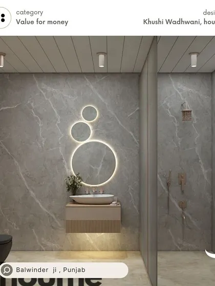 A value-for-money bathroom design for Balwinder in Punjab, featuring large grey marble-finish tiles, a unique circular backlit mirror, and a floating vanity to create a sense of space.