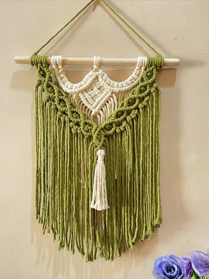 A classic two-tone macrame wall hanging. The contrast between the natural off-white and the olive green cord highlights the different knotting patterns used in the design.