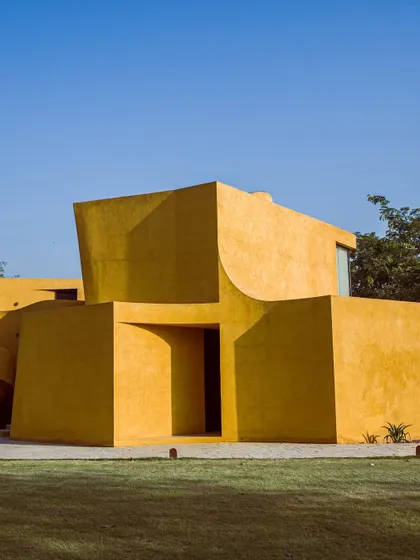 The stark geometry of the building under the bright Delhi sun, creating deep, dramatic shadows.