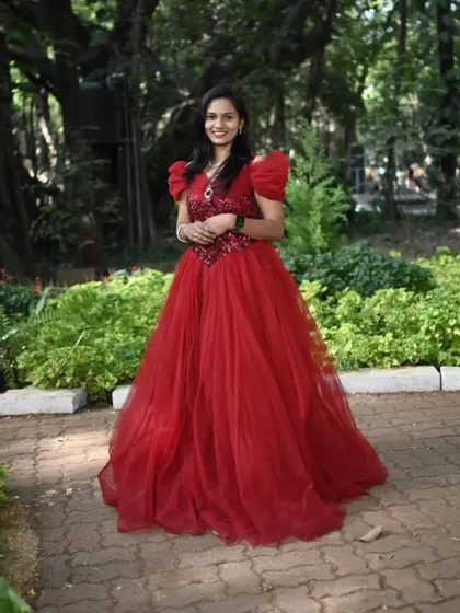 A full-length shot of this lovely red ball gown. The puffed sleeves and sequined bodice add a touch of glamour, perfect for a pre-wedding celebration.