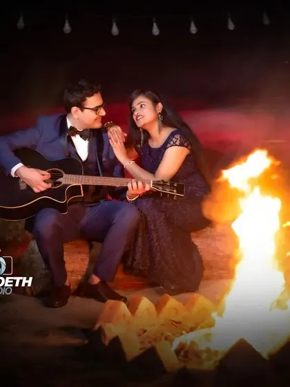A classic campfire scene, perfect for a musical couple. The fire provides a beautiful, natural light source for a warm and intimate pre-wedding portrait.