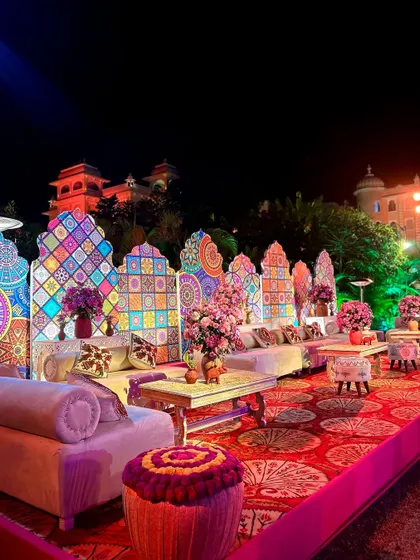 A comfortable and stylish lounge seating area with a colorful, patterned backdrop for a royal Sangeet at The Everest Hill Resort, Kumbhalgarh.
