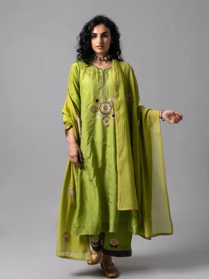 A lime green kurta set with subtle, artistic embroidery. This is a perfect example of a "minimal yet majestic" piece, where the beauty is in the unique details and the quality of the fabric.