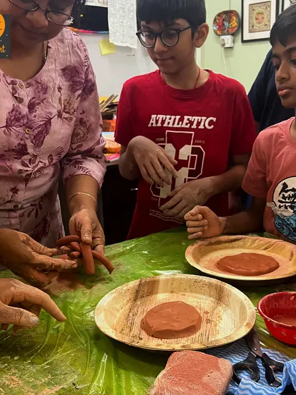 Here I am guiding students as they learn to roll and shape clay coils. This foundational pottery technique is a great hands-on way to connect with history and art.