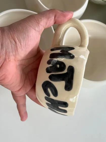 A fun, hand-painted "Matcha" mug that was part of the custom cafe order. The bold, simple lettering has a playful feel.