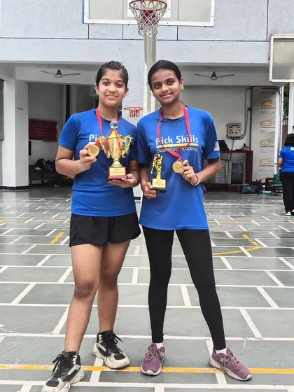 Two of our standout players from the junior girls' team proudly displaying their winner's trophy and MVP award. Their performance is a direct result of the discipline and advanced skills we cultivate at the academy.