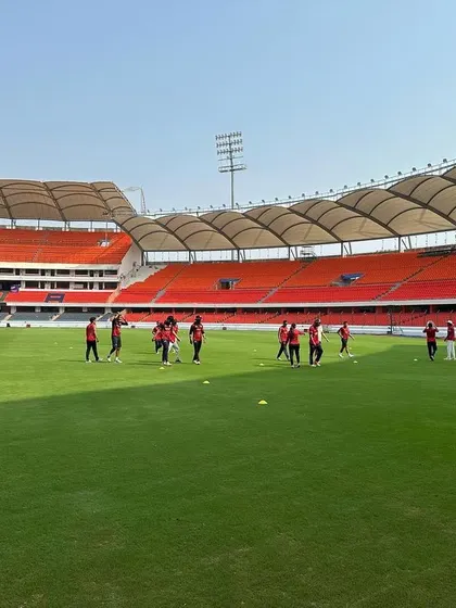 The team warming up on the lush green outfield. Preparation is key.