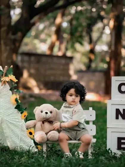 A calm and sweet portrait of a one-year-old boy in a natural park setting.