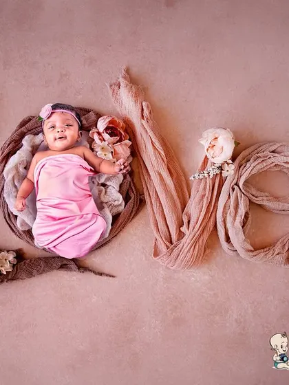 A sweet newborn portrait where the baby is nestled in a basket, with the word "LOVE" spelled out using soft fabrics and flowers. It's a simple yet powerful way to express your feelings for your new baby.