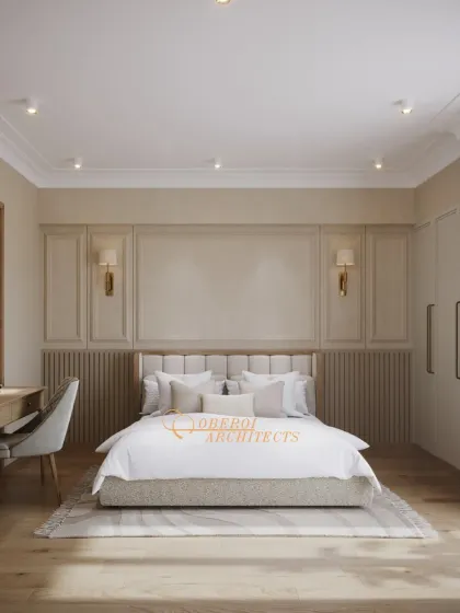 A full view of the bedroom, highlighting the classic wall paneling, symmetrical sconces, and a dedicated workspace, all in a calming neutral palette.