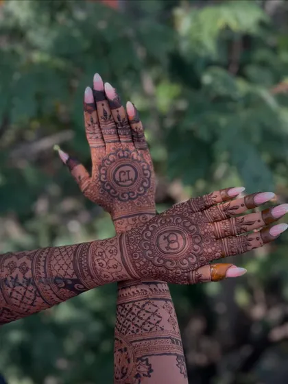 A creative pose showing the crossed arms, which brings the two central mandala designs with the initials together.