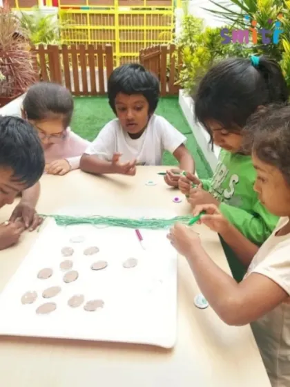 Children work together at a table, focused on the intricate task of making Rakhis. This activity promotes concentration, patience, and teamwork.