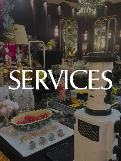 A wide shot of a fully serviced event bar, complete with a fruit display, marshmallows for garnishes, and our professional team ready to serve. We provide an end-to-end service.