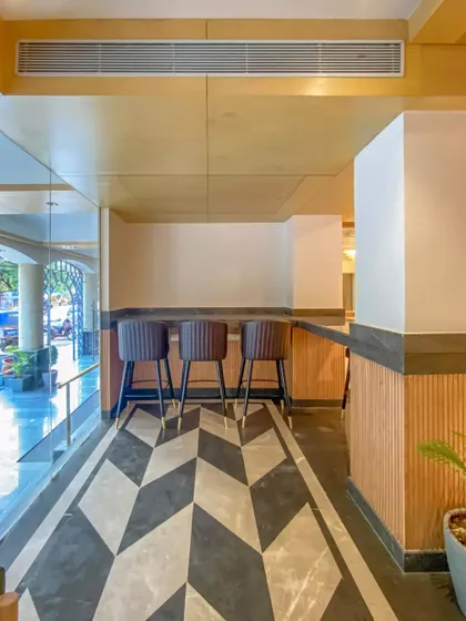 Another view of the bar area in Bhopal, showing the open-air connection to the hotel entrance. The geometric flooring creates a visual path, guiding guests into the space.
