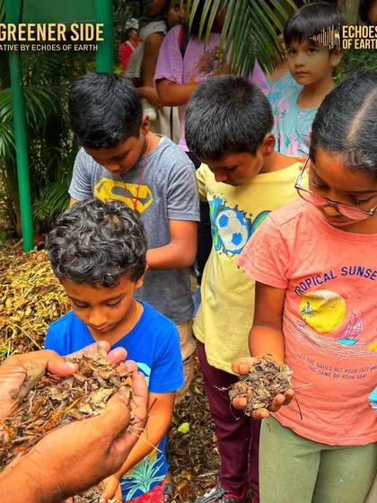 Children examining handfuls of leaf litter, learning about decomposition and the hidden life on the forest floor as part of a journaling session.