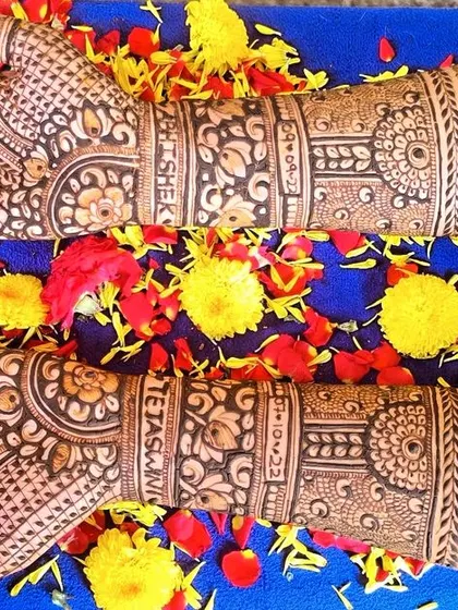 Peacock-themed bridal mehendi laid against a bed of flowers. The details in the peacock feathers and the surrounding patterns are what make this design special.