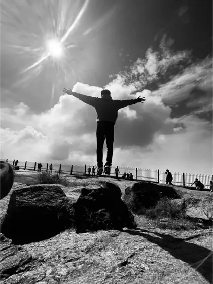 A dramatic black and white shot capturing the feeling of freedom at Nandi Hills. It's just you, the sky, and the clouds.