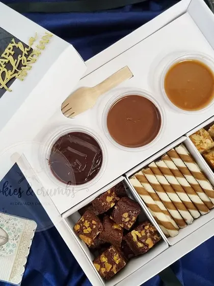 The complete Rakshabandhan Dipping Box. It includes walnut brownie bites, choco wafer rolls, and nutty vanilla tea cake bites, paired with chocolate ganache, Nutella, and my homemade salted caramel sauce.