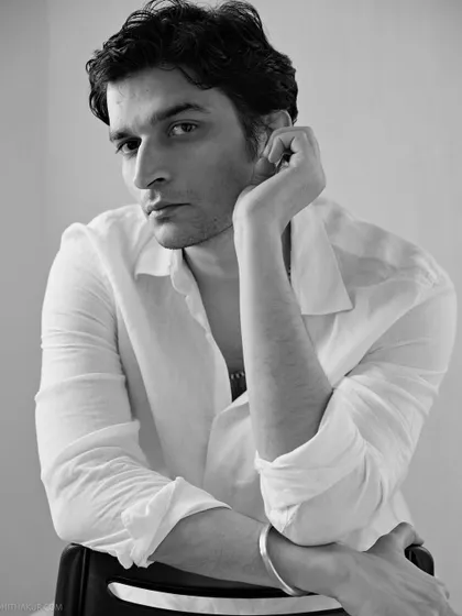 An intimate and gentle black and white portrait. The soft light and relaxed pose create a feeling of quiet contemplation, perfect for a sensitive and authentic headshot.