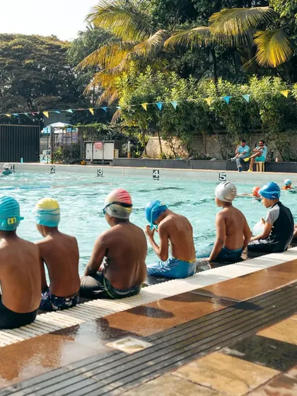 A typical scene from our kids' class. Students listen to instructions before their next drill, learning discipline alongside swimming skills.