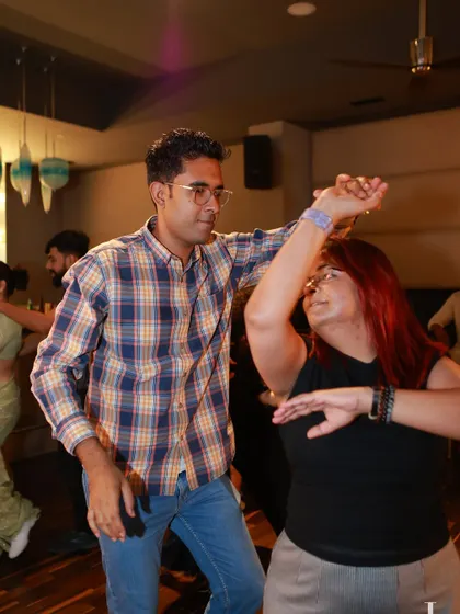 A man confidently leads his partner in a turn. This shot captures the essence of leading and following in partner dancing.
