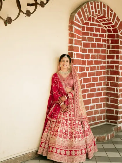 A classic full-length bridal portrait against a rustic brick archway.