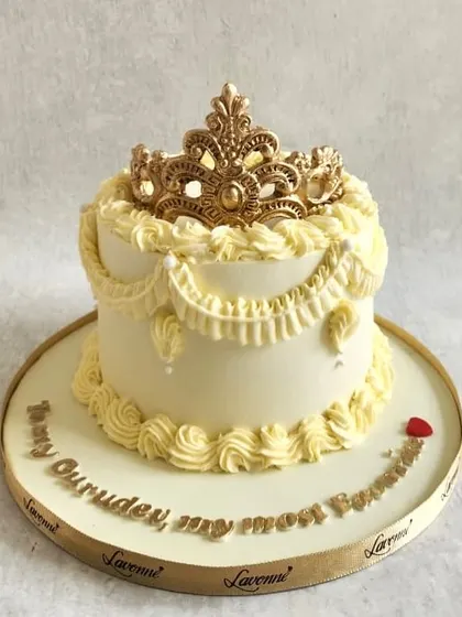 A cake fit for royalty! This piece features elegant buttercream swags and is topped with a golden sugar-lace crown. It shows how you can combine different piping techniques to create a truly regal effect.