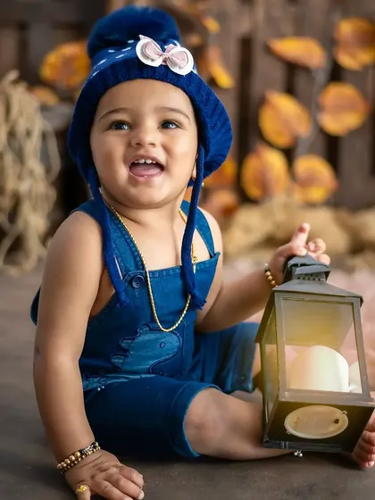 A happy boy in our rustic setup, holding a lantern prop. We use props to keep babies engaged and capture their curiosity.