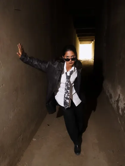 A dynamic walking-towards-the-camera shot, creating a sense of movement and confrontation. The light at the end of the tunnel adds a focal point.