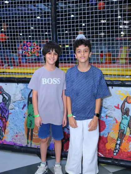 Two friends stand in front of our cool graffiti art wall, a popular photo spot in the park.