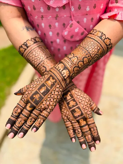 This angle highlights the elephant procession motif on the forearm, a classic symbol of celebration.