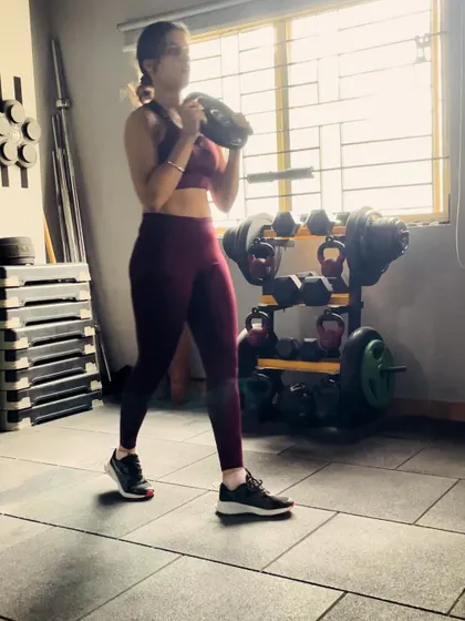 A snapshot from a training session, holding a weight plate for a goblet squat. This exercise is amazing for building lower body strength, particularly in the quads and glutes, while also engaging the core to keep the torso upright.