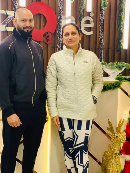 A trainer and member duo standing by the Christmas tree, showcasing the supportive environment we foster.