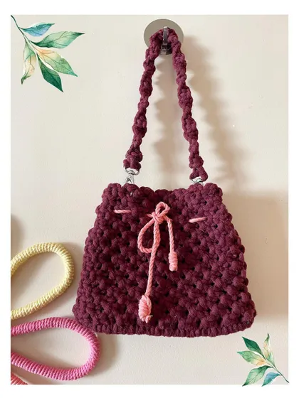 A deep maroon shoulder bag that's perfect for both western and traditional outfits. The contrasting light pink drawstring adds a subtle pop of color.