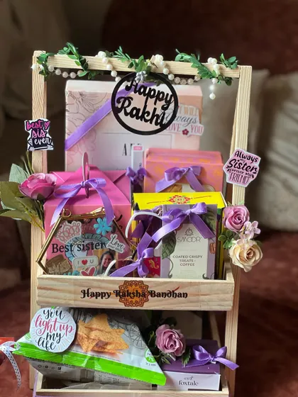 A beautifully decorated two-tiered hamper for a sister, featuring personalized elements like a "Best Sister" frame and photos.