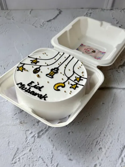 An elegant Eid Mubarak bento cake with a minimalist design of hanging lanterns and stars. It's a simple yet beautiful treat for the festival.