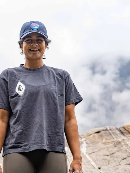 A portrait of one of our smiling climbers, standing proud on the rock. Each person's journey is unique, and we celebrate every individual's growth.