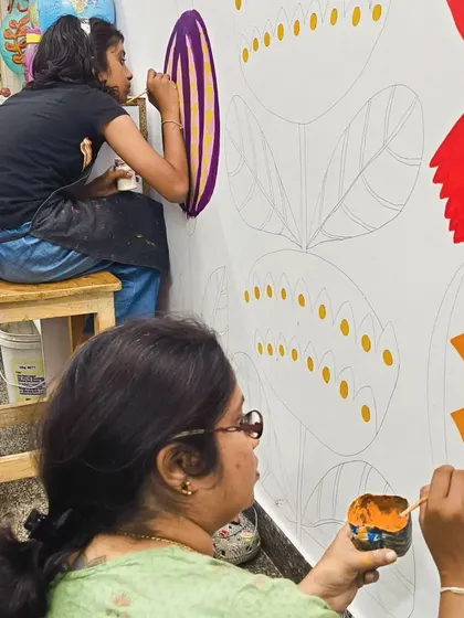 My student and I work together on a large-scale floral mural for our sensory classroom, inspired by the whimsical art of Mary Blair.