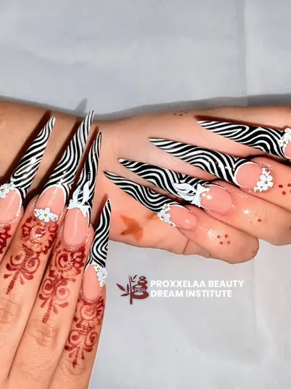 This angle showcases the dramatic length and sharp point of the zebra print stiletto nails, a truly head-turning set.