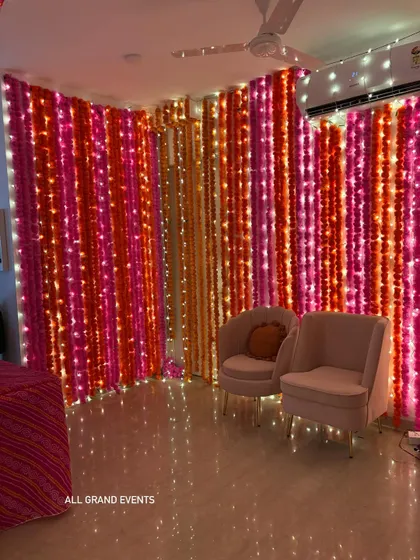 A different angle of the marigold wall decor, showing how it creates a warm and inviting corner with two elegant chairs for guests.