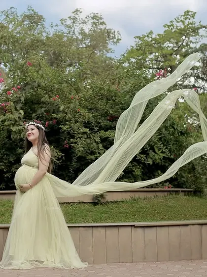 Creating a dynamic sense of movement, the long train of this light green gown flows in the wind during an outdoor park session.