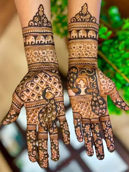 A beautifully lit shot of the peacock and elephant themed engagement mehendi.