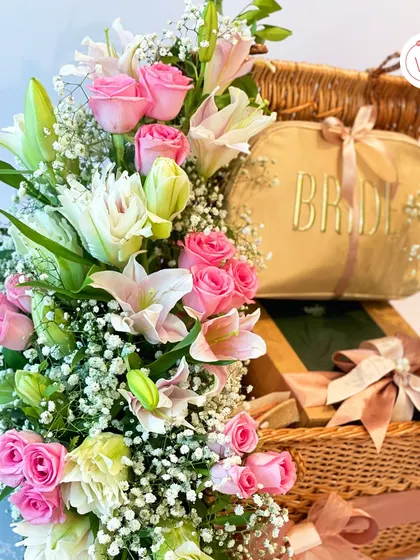 A beautiful shot of the floral arrangement in the bride's hamper, featuring pink roses and white lilies.