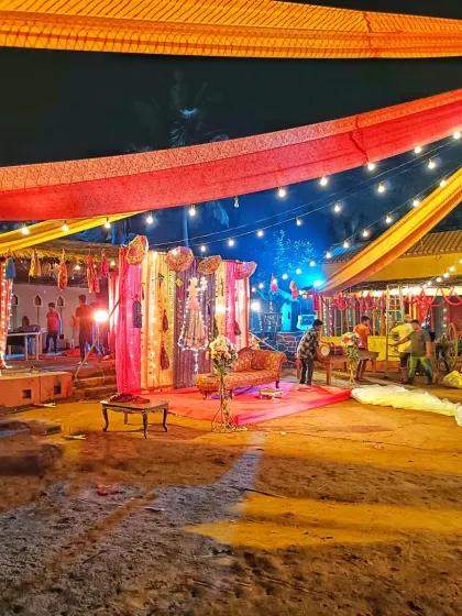 A wide view of the outdoor venue for the traditional Rajasthani-themed baby shower. The setup includes a decorated stage area and colorful fabric draping across the open space.