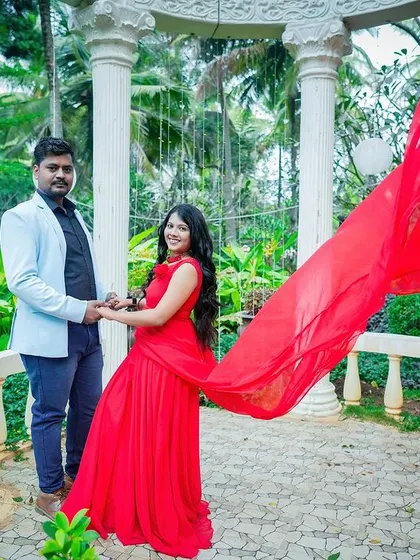 A dramatic shot in a white gazebo, with the bride's red dress flowing in the wind.