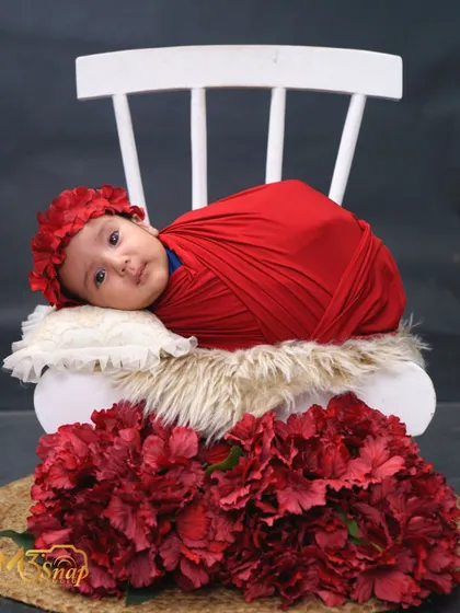 A slightly different angle showing the baby's full setup. The combination of the chair, fur, and flowers creates a rich and beautiful composition.