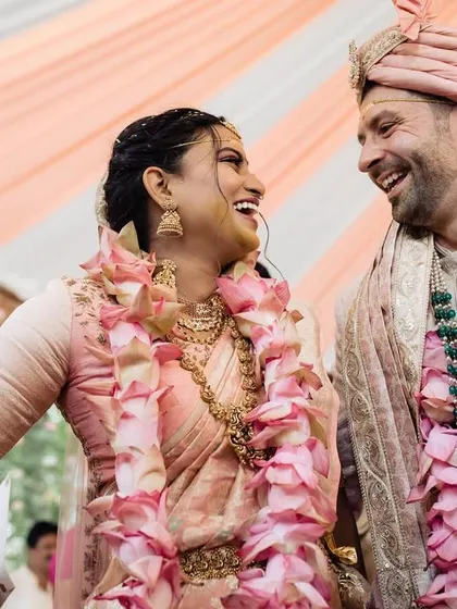 Shared laughter between a multicultural couple during their wedding ceremony. This image perfectly captures the blending of traditions and the personal connection that makes their day unique.